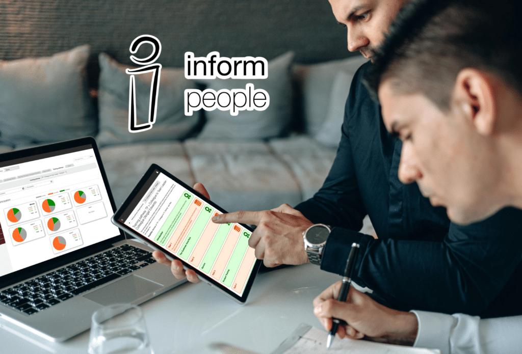 two people look at a tablet and computer showing the inform people Pathways module