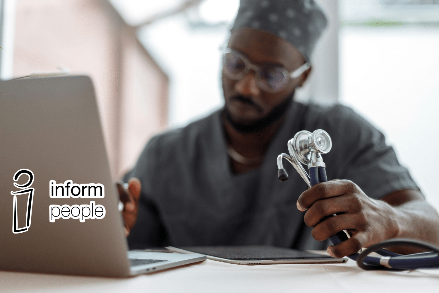 doctor looking at laptop - with inform people logo